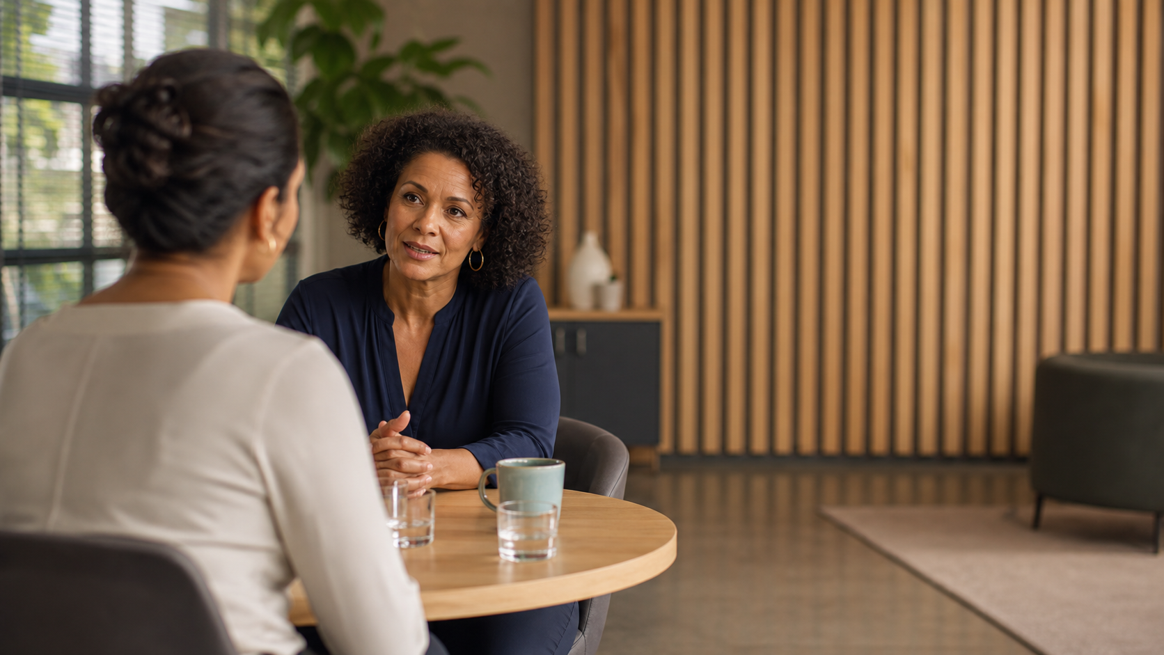 A manager having a calm, empathetic one-to-one conversation with a colleague